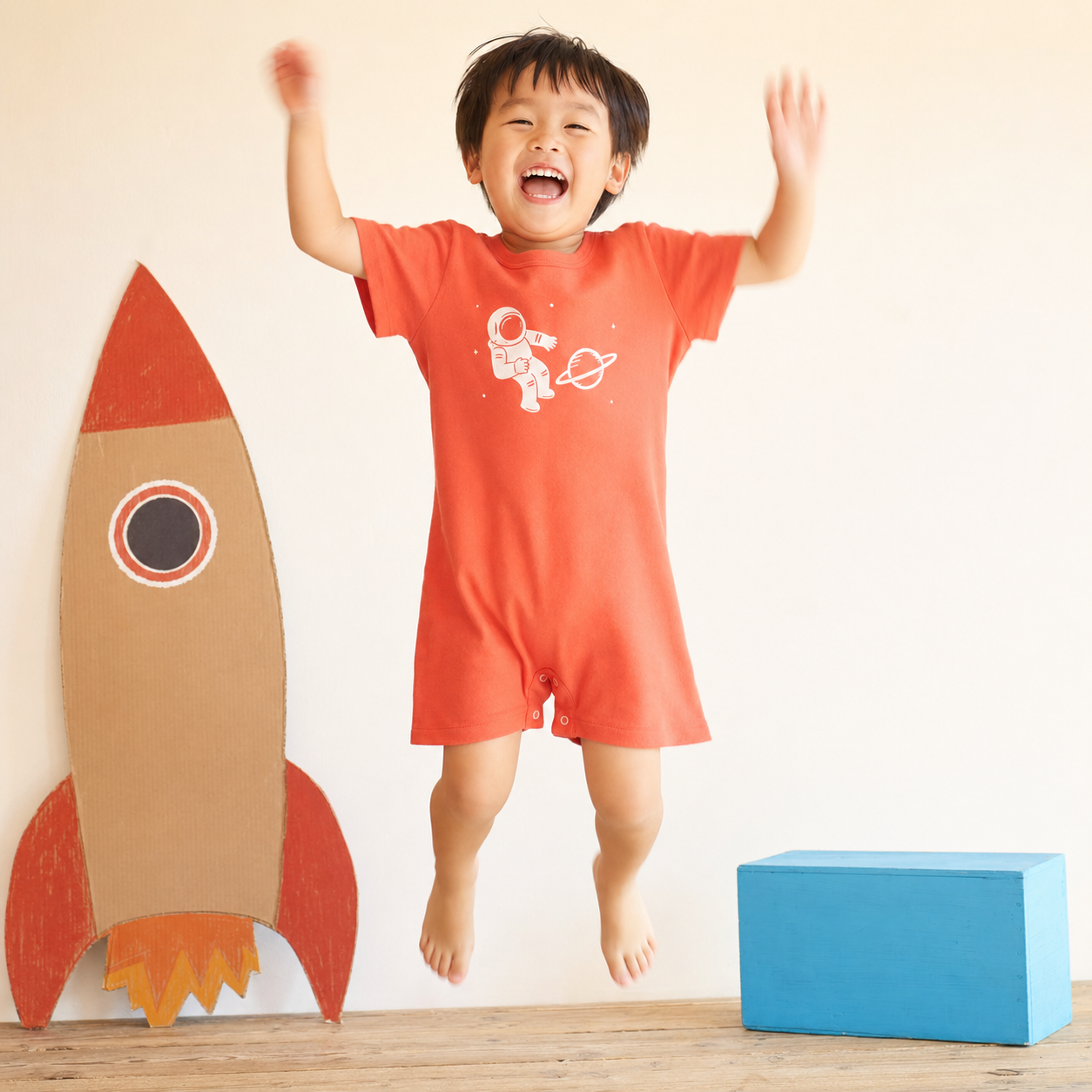 珊瑚紅小太空人連身裝穿在小孩身上跳躍