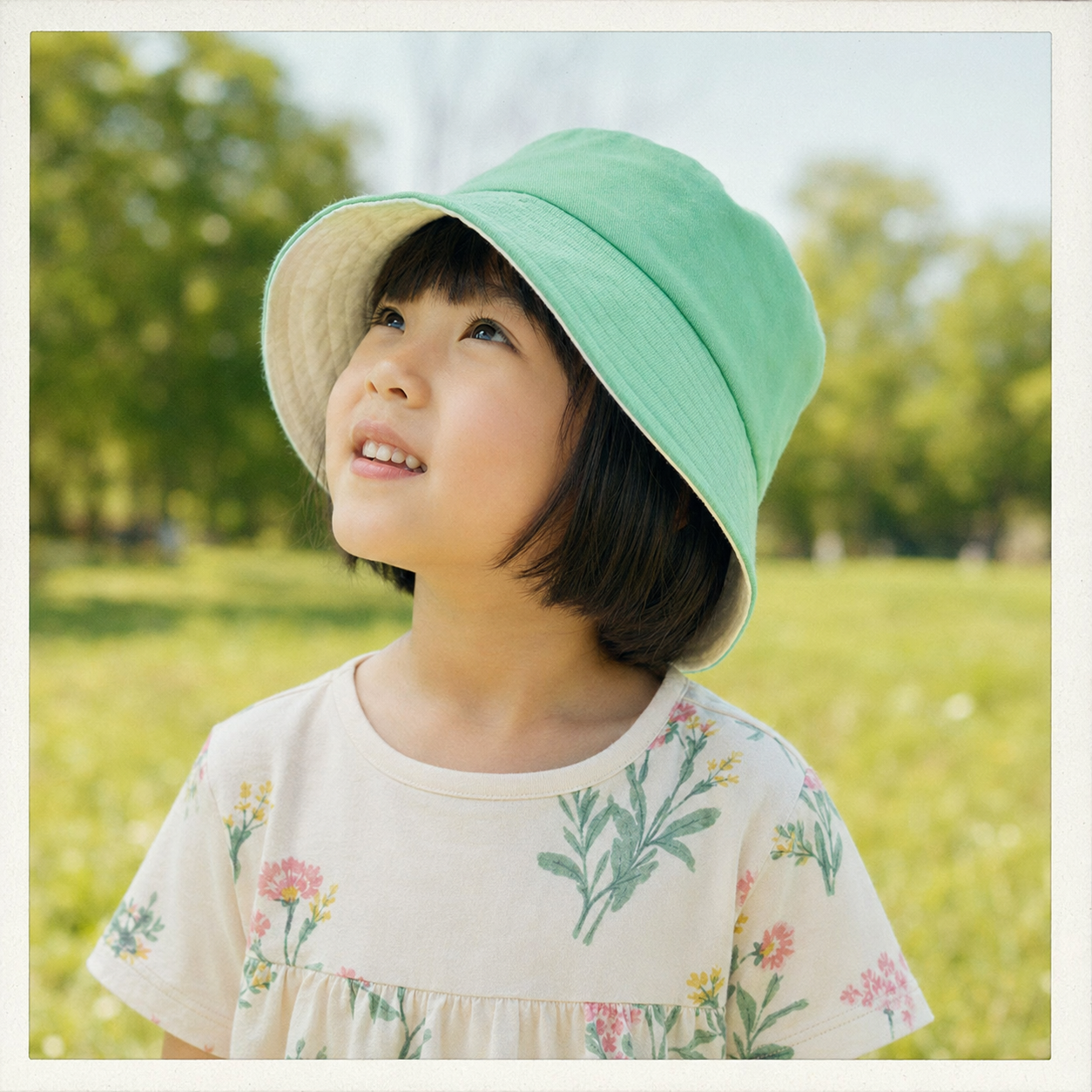 薄荷綠雙面漁夫帽戴在小孩頭上於公園草地